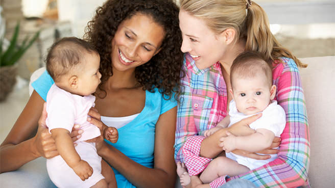 two moms sitting with babys on their lap